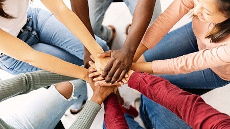 group puts hands together in a circle